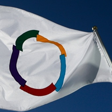 Weiße Fahne vor blauem Hintergrund mit einem bunten Kreis